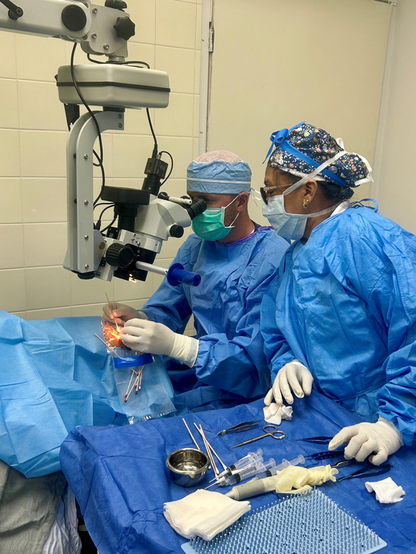 two doctors performing eye surgery in an operating room